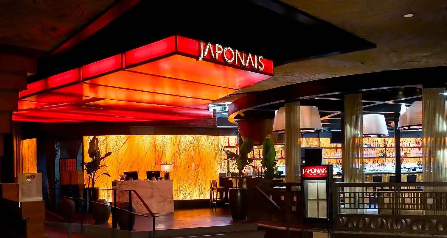 | Las Vegas Awning and StructuresA stylish restaurant entrance features a glowing red and orange awning with the name "Japonais." The modern design highlights the ambiance, showcasing the importance of commercial awnings for sun protection and aesthetic appeal in Las Vegas.